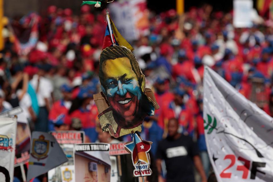 A student waves a banner decorated with an image of Venezuela's late President Hugo Chavez at a gathering between President Nicolas Maduro and students in Caracas, Venezuela, Saturday, March 22, 2014. Two more people were reported dead in Venezuela as a result of anti-government protests even as supporters and opponents of Maduro took to the streets on Saturday in new shows of force. (AP Photo/Esteban Felix)