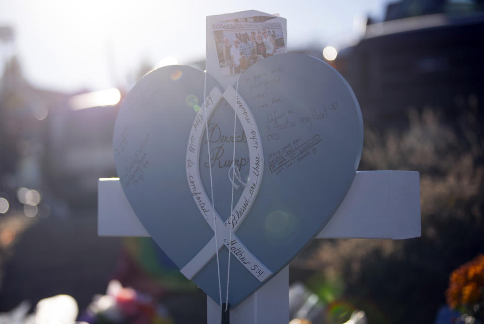 A photograph of Derrick Rump and friends sits on top of a cross dedicated to him at a memorial outside of Club Q on Monday, Nov. 21, 2022 in Colorado Springs, Colo. (AP Photo/Parker Seibold)