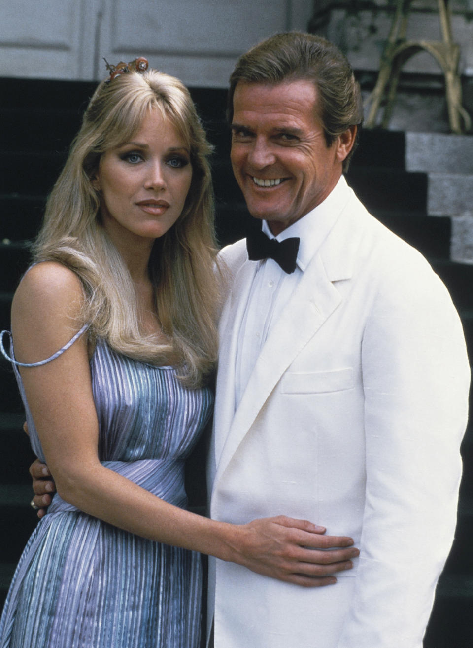 ARCHIVO – El actor Roger Moore, derecha, posa con su coestelar Tanya Roberts de la película de James Bond "A View to a Kill" fuera de Château de Chantilly en Chantilly, Francia el 17 de agosto de 1984. Roberts, quien cautivó a James Bond en "A View to a Kill" y actuó en la comedia "That '70s Show" falleció el lunes 4 de enero de 2021, varias horas después de que fuera reportada muerta por error por su publicista y su pareja. La pareja de Roberts Lance O'Brien confirmó su muerte el martes tras recoger sus pertenencias en un hospital de Los Angeles hospital. Tenía 65 años. (Foto AP /Alexis Duclos, archivo)