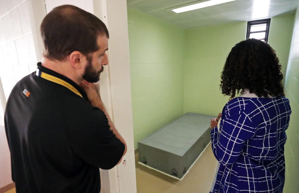 Cuyahoga Juvenile Detention Center Assistant Superintendent Jason Lanzo, left, and Deputy Director of Programming Celeste Wainwright take a look inside one of the female cells, Tuesday, July 25, 2023, in Cleveland, Ohio.