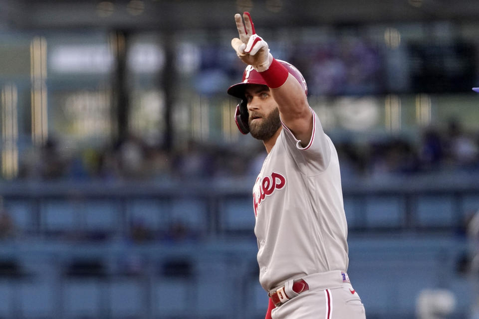 Philadelphia Phillies' Bryce Harper gestures toward his dugout after hitting a double during the first inning of a baseball game against the Los Angeles Dodgers Saturday, May 14, 2022, in Los Angeles. (AP Photo/Mark J. Terrill)