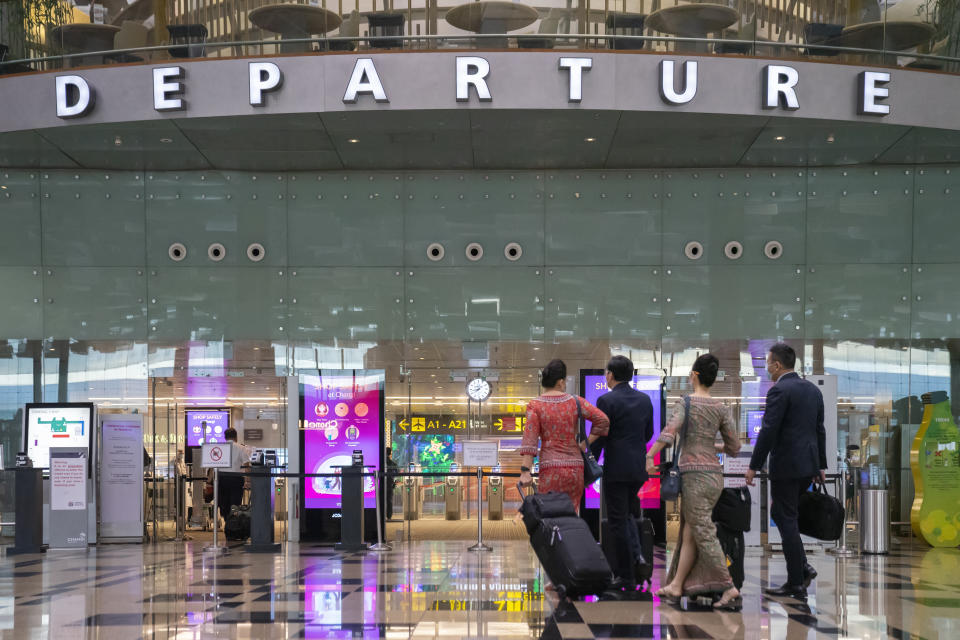 Singapore, Singapore - November 7, 2021: Cabin crew with Singapore Airlines walk towards the departure gate at Terminal 3, Changi Airport.