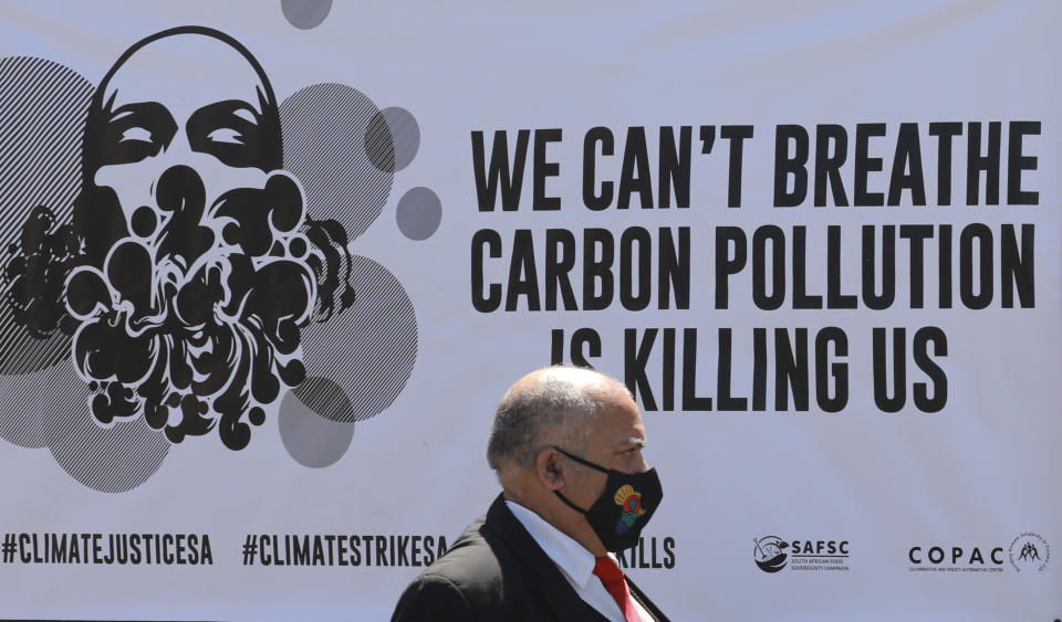 An activist protests for climate justice outside parliament in Cape Town, South Africa, Tuesday, Nov. 9, 2021. The protest coincides with the second week of as the COP26, UN Climate Summit in Glasgow. (AP Photo/Nardus Engelbrecht)