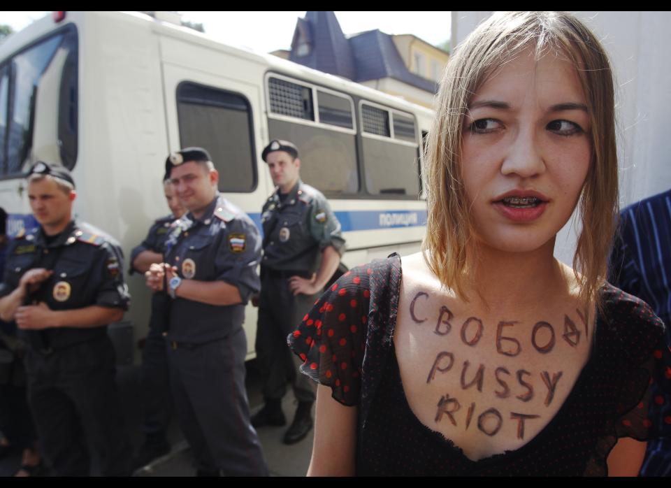 Police stand guard as a supporter of punk band Pussy Riot pickets a Moscow court, Wednesday, July 4, 2012. 