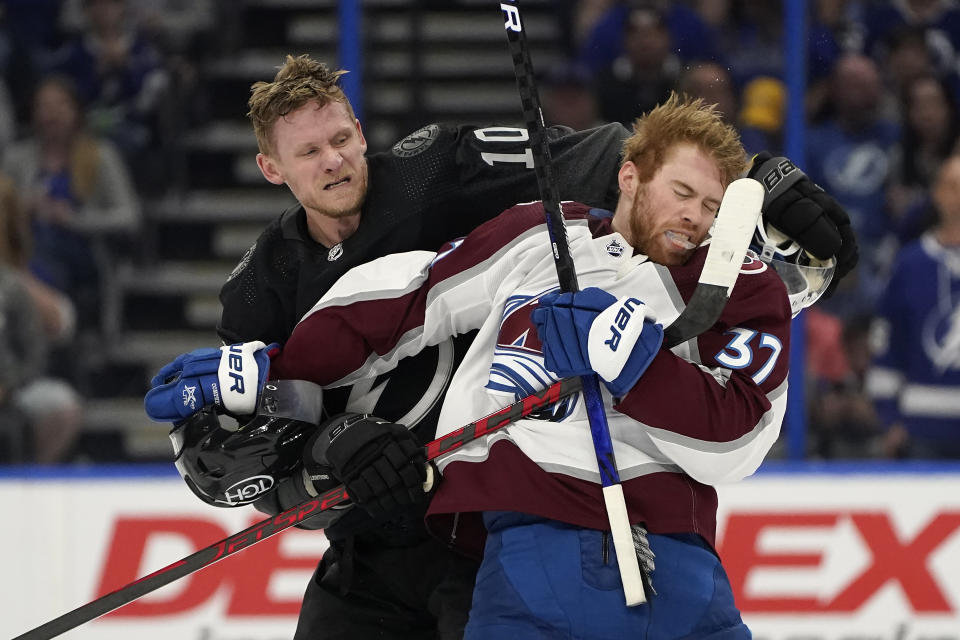 Tampa Bay Lightning right wing Corey Perry (10) and Colorado Avalanche left wing J.T. Compher (37) scrap during the second period of an NHL hockey game Saturday, Oct. 23, 2021, in Tampa, Fla. (AP Photo/Chris O'Meara)