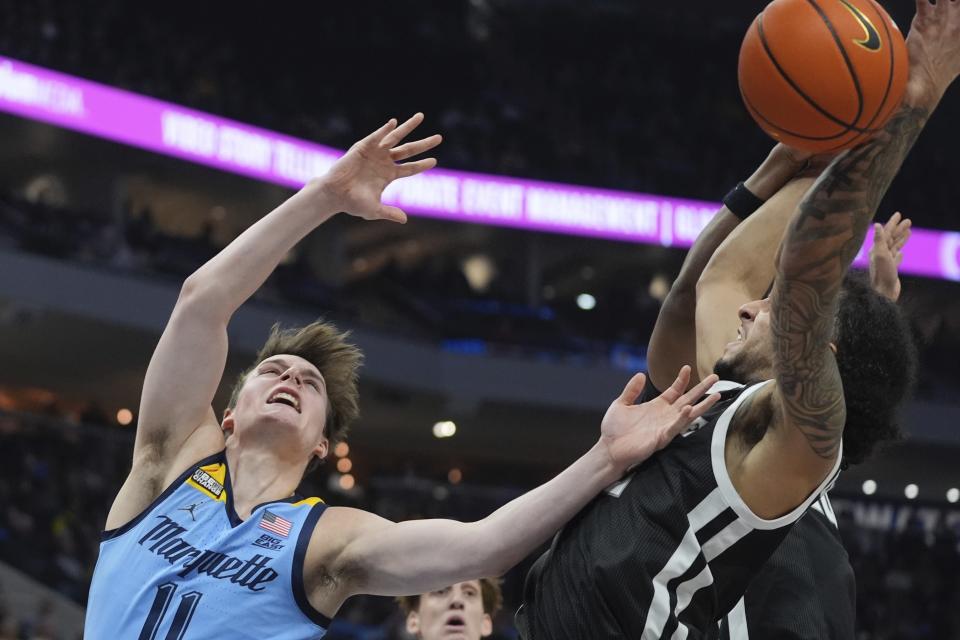 Marquette's Tyler Kolek is fouled by Providence's Devin Carter during the first half of an NCAA college basketball game Wednesday, Feb. 28, 2024, in Milwaukee. (AP Photo/Morry Gash)