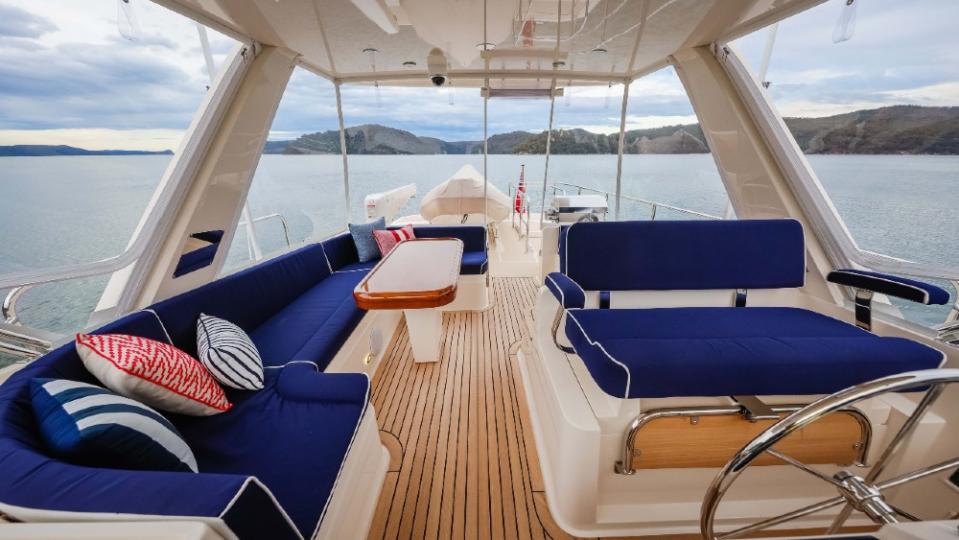 A seriously retro feel to the flybridge, with the navy upholstery and pinstripe teak floors.