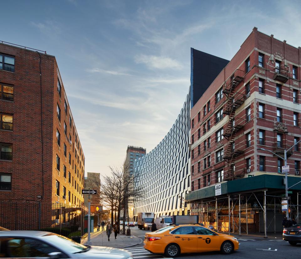 A sleek curve defines the facade of The Smile, which is currently rising in East Harlem.