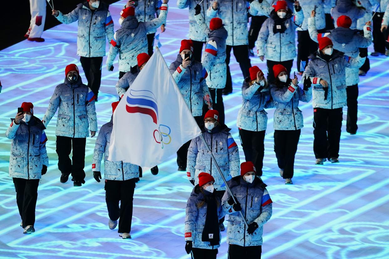 Olga Fatkulina and Vadim Shipachyov, of the Russian Olympic Committee, carry a flag into the stadium during the opening ceremony of the 2022 Winter Olympics.