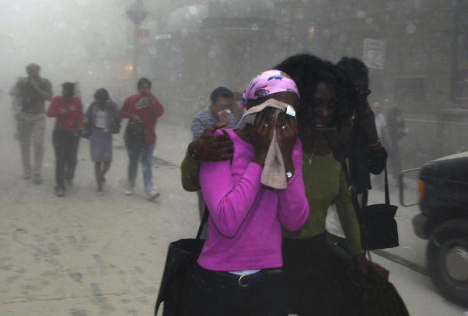 <p>People cover their faces as they escape the collapse of New York's World Trade Center on Sept. 11, 2001. (AP Photo/Suzanne Plunkett)</p> 