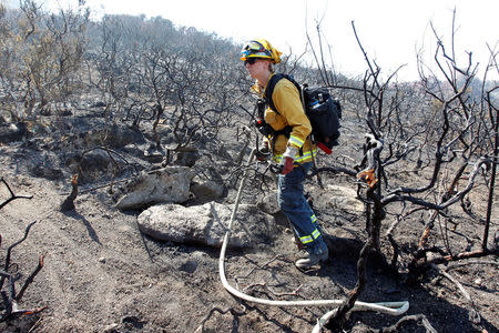 Firefighter Asha Whipple from the Woodland Fire Department looks for hotspots during the Soberanes Fire in the mountains above Carmel Highlands, California, U.S. July 28, 2016. REUTERS/Michael Fiala