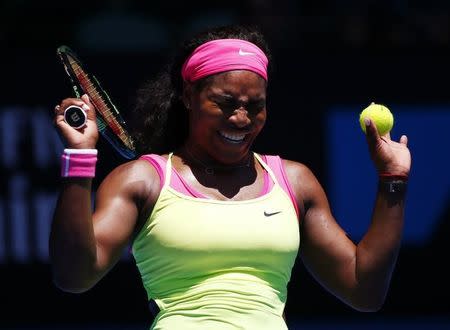 Serena Williams of the U.S. reacts from the glare of the sun while trying to serve against Vera Zvonareva of Russia during their women's singles second round match at the Australian Open 2015 tennis tournament in Melbourne January 22, 2015. REUTERS/Issei Kato