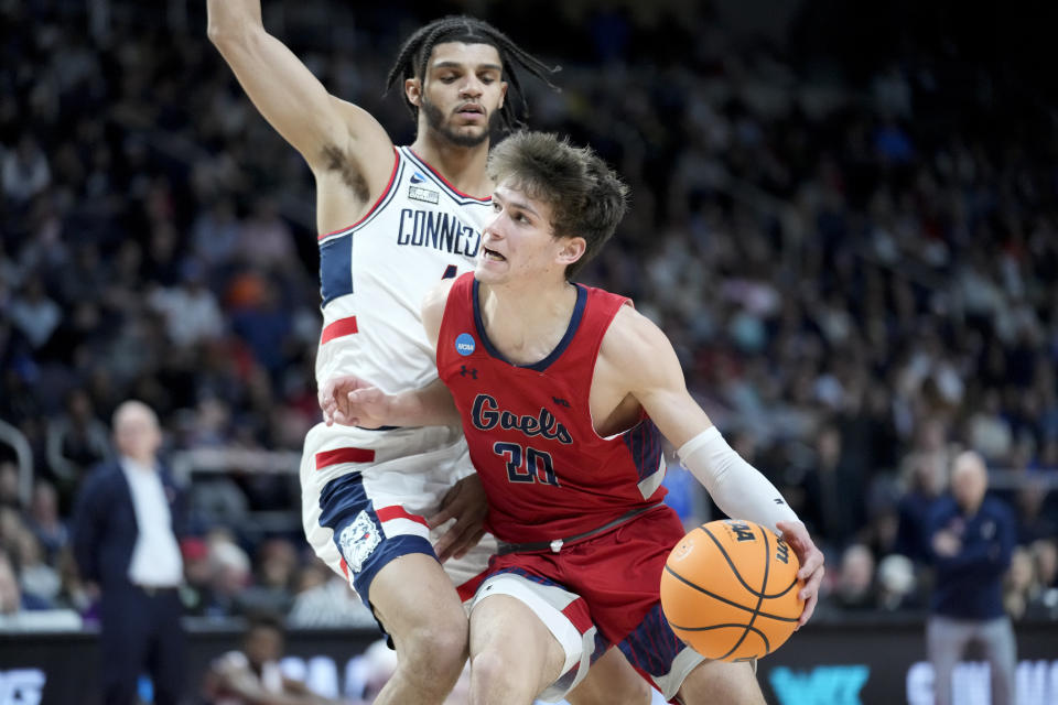 St. Mary's Aidan Mahaney (20) drives against Connecticut's Nahiem Alleyne, left, in the first half of a second-round college basketball game in the NCAA Tournament, Sunday, March 19, 2023, in Albany, N.Y. (AP Photo/John Minchillo)
