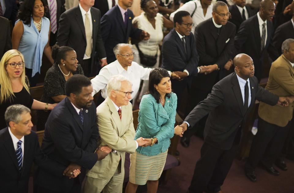 South Carolina Gov. Nikki Haley, center right, joins hands with Charleston Mayor Joseph Riley, left, and Sen. Tim Scott, R-S.C., right, at a memorial service at Morris Brown AME Church for the people killed Wednesday during a prayer meeting inside the historic black church in Charleston, S.C., Thursday, June 18, 2015.