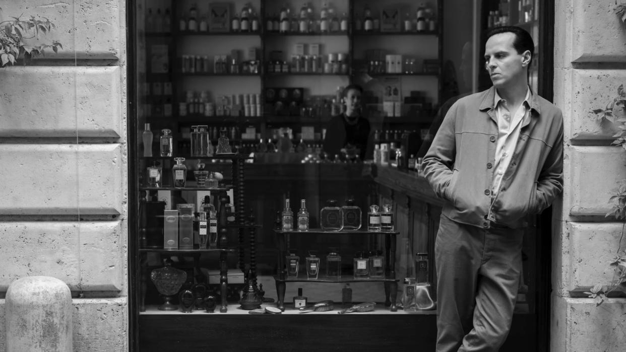  Black-and-white shot of Andrew Scott as Tom Ripley leaning against a shop window. 