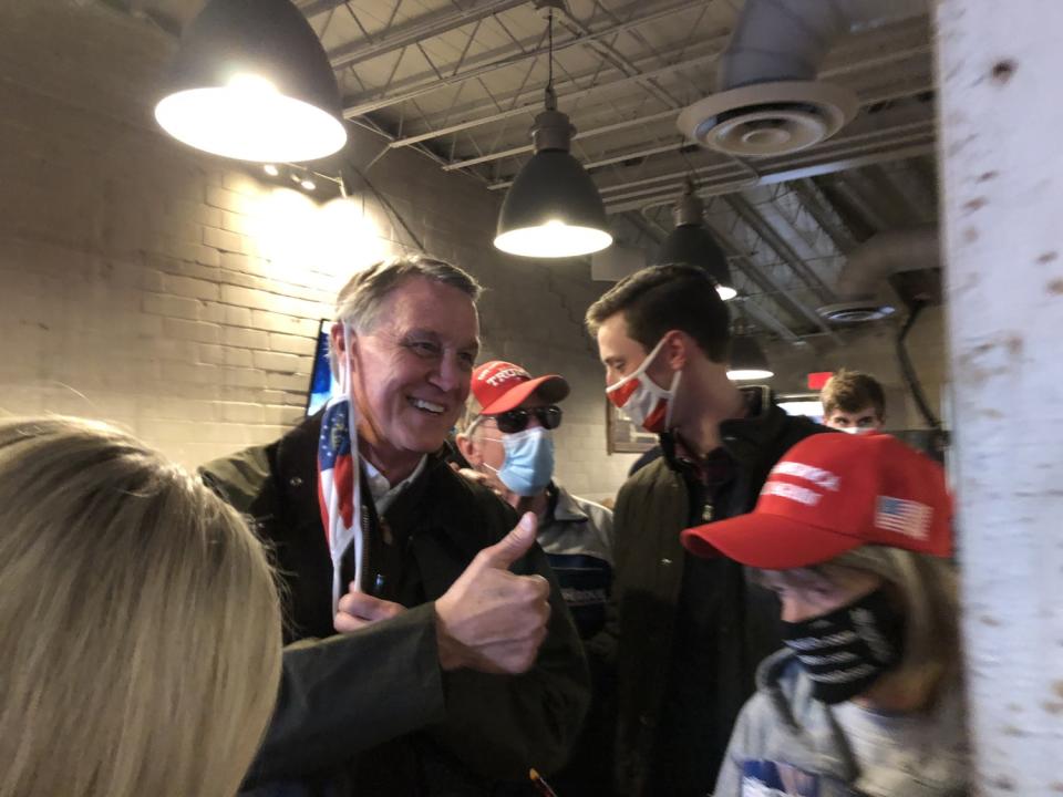 Sen. David Perdue takes his mask off for a photo at a rally in Dalton, Ga.