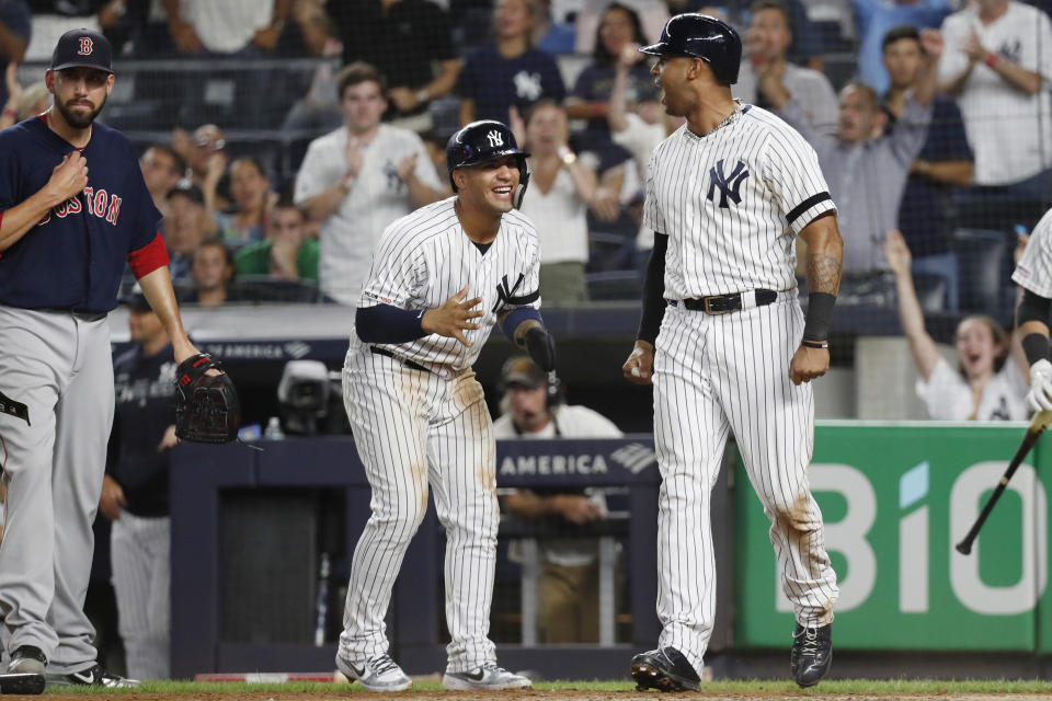 New York Yankees' Aaron Hicks, right, reacts after he and Gleyber Torres, center, scored on Mike Tauchman's seventh-inning, two-run single in the second baseball game of a doubleheader against the Boston Red Sox, Saturday, Aug. 3, 2019, in New York. (AP Photo/Kathy Willens)