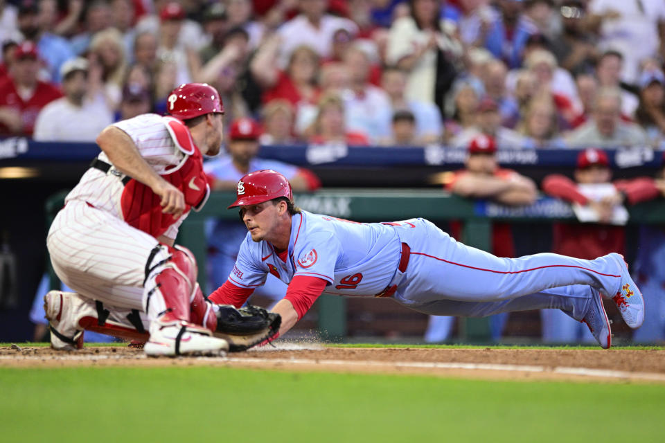 St. Louis Cardinals' Nolan Gorman dives to score a run past Philadelphia Phillies' J.T. Realmuto during the third inning of a baseball game Saturday, June 1, 2024, in Philadelphia. (AP Photo/Derik Hamilton)