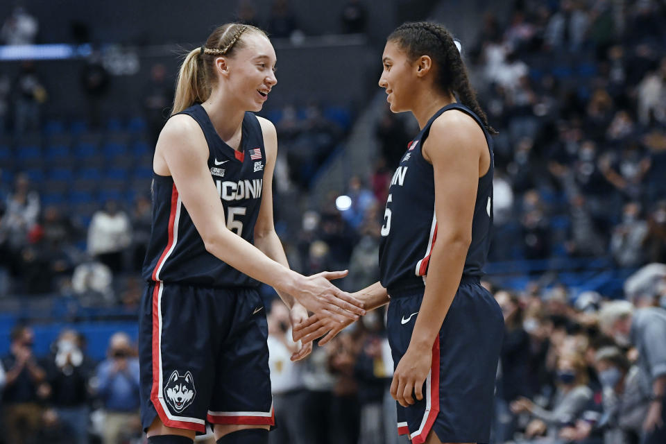 Connecticut's Paige Bueckers, left, shakes hands with teammate Azzi Fudd at the end of an NCAA college basketball game against Arkansas, Sunday, Nov. 14, 2021, in Hartford, Conn. (AP Photo/Jessica Hill)