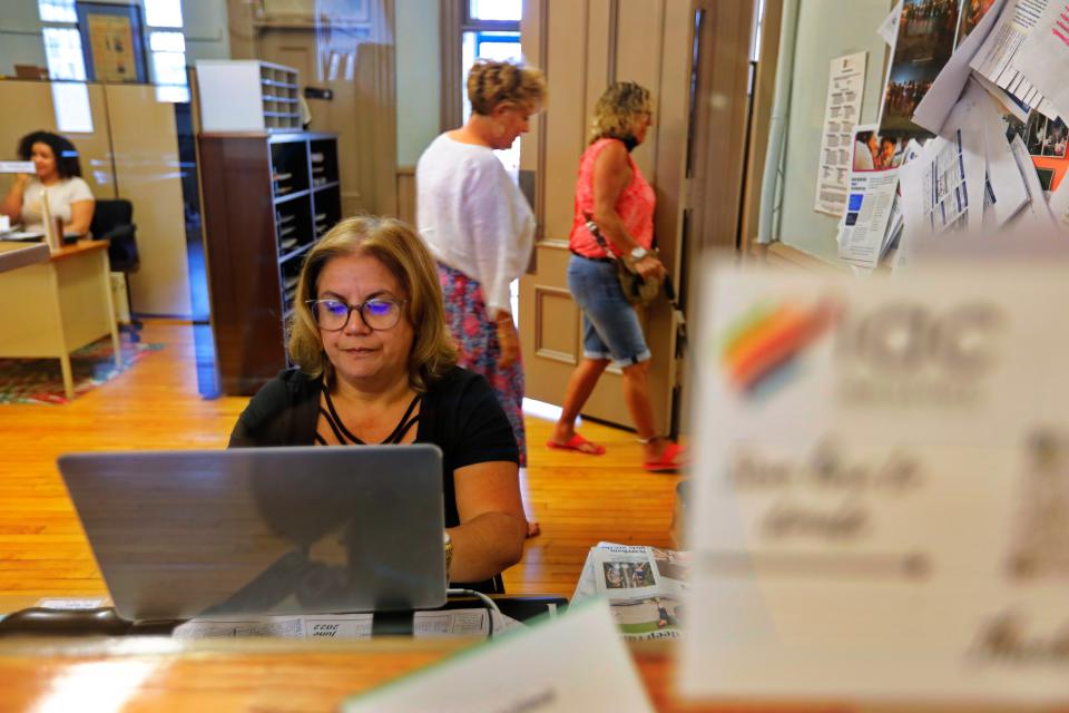 Delia Moreira is seen at the front desk of the Immigrants Assistance Center on the second floor of Casa da Saudade on Crapo Street in New Bedford.