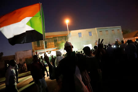 A Sudanese protester waves a national flag and and makes victory sign as he arrives a mass protest in front of the Defence Ministry in Khartoum, Sudan, April 21, 2019. REUTERS/Umit Bektas