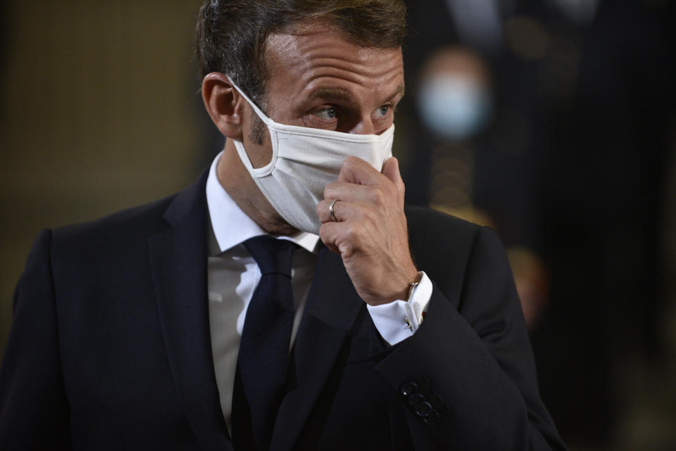 French President Emmanuel Macron adjusts his mask during a ceremony to celebrate the 150th anniversary of the proclamation of the Republic, at the Pantheon monument, Friday Sept.4. 2020 in Paris. (Julien de Rosa, Pool via AP)