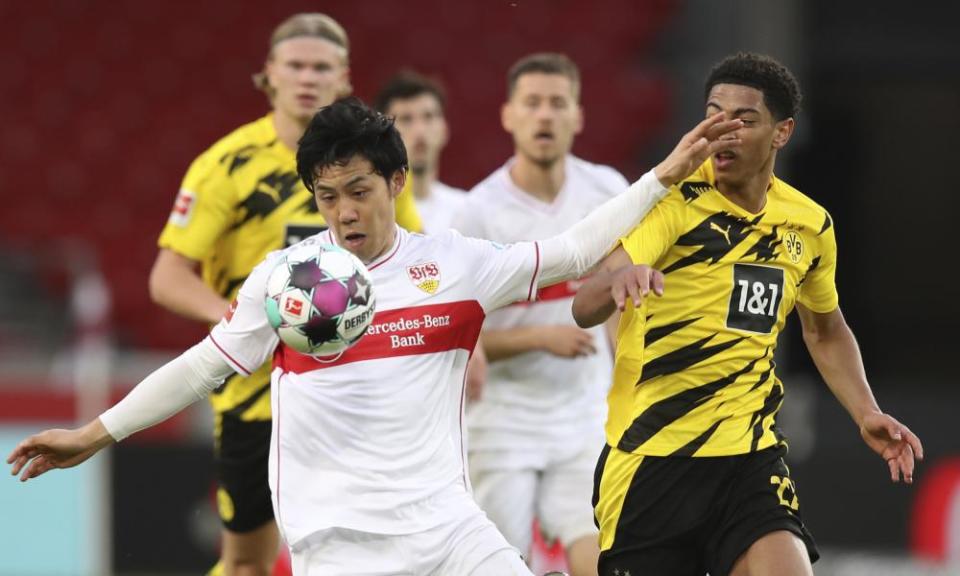 Wataru Endo, here holding off Borussia Dortmund’s Jude Bellingham, is not making millions for Stuttgart in shirt sales.