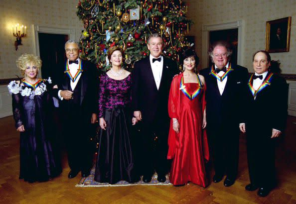 2002: Actress Elizabeth Taylor, actor James Earl Jones, first lady Laura Bush, U.S. President George W. Bush, actress Chita Rivera, conductor James Levine and singer Paul Simon pose for a picture after the Kennedy Center Honors of 2002 recipients were honored at the White House on December 8, 2002, in Washington, D.C.