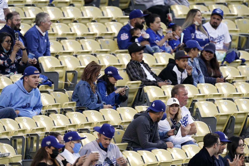 FILE - In this Friday, May 14, 2021, file photo, several fans are seen without masks as they watch the Miami Marlins play the Los Angeles Dodgers in a baseball game in Los Angeles. California's top health official says the state will no longer require social distancing and will allow full capacity for businesses when the state reopens on June 15. State health director Dr. Mark Ghaly said Friday, May 21, that dramatically lower virus cases and increasing vaccinations mean it's safe for the state to remove nearly all restrictions next month. (AP Photo/Mark J. Terrill, File)