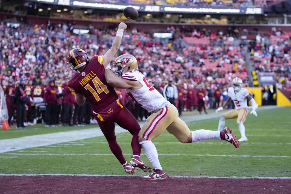 Washington Commanders quarterback Sam Howell (14) throws the ball before getting hit by San Francisco 49ers defensive end Nick Bosa (97) during the second half of an NFL football game, Sunday, Dec. 31, 2023, in Landover, Md. San Francisco won 27-10. (AP Photo/Mark Schiefelbein)