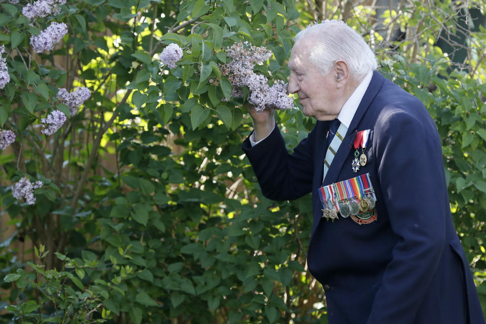 World War II Veteran Mervyn Kersh smells one of the plants in his garden in London, Monday, May 4, 2020. On Friday's 75th anniversary of the end of World War II in Europe, talk of war is afoot again — this time against a disease that has killed at least a quarter of a million people worldwide. Instead of parades, remembrances and one last great hurrah for veterans now mostly in their nineties, it is a time of lockdown and loneliness, with memories bitter and sweet (AP Photo/Frank Augstein)