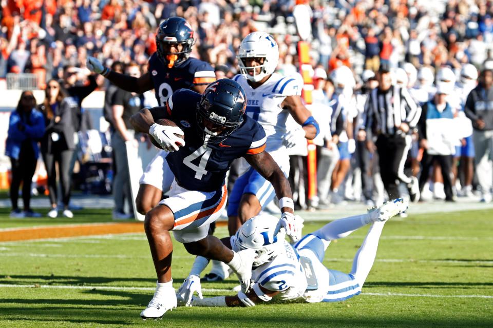 Nov 18, 2023; Charlottesville, Virginia, USA; Virginia Cavaliers wide receiver Malik Washington (4) scores a touchdown as Duke Blue Devils safety Jaylen Stinson (2) chases during the first quarter at Scott Stadium. Mandatory Credit: Geoff Burke-USA TODAY Sports