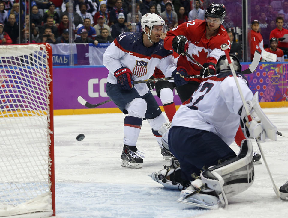 Canada forward Benn Jamie, right, shoots and scores against USA goaltender Jonathan Quick during the second period of a men's semifinal ice hockey game at the 2014 Winter Olympics, Friday, Feb. 21, 2014, in Sochi, Russia. (AP Photo/Julio Cortez)