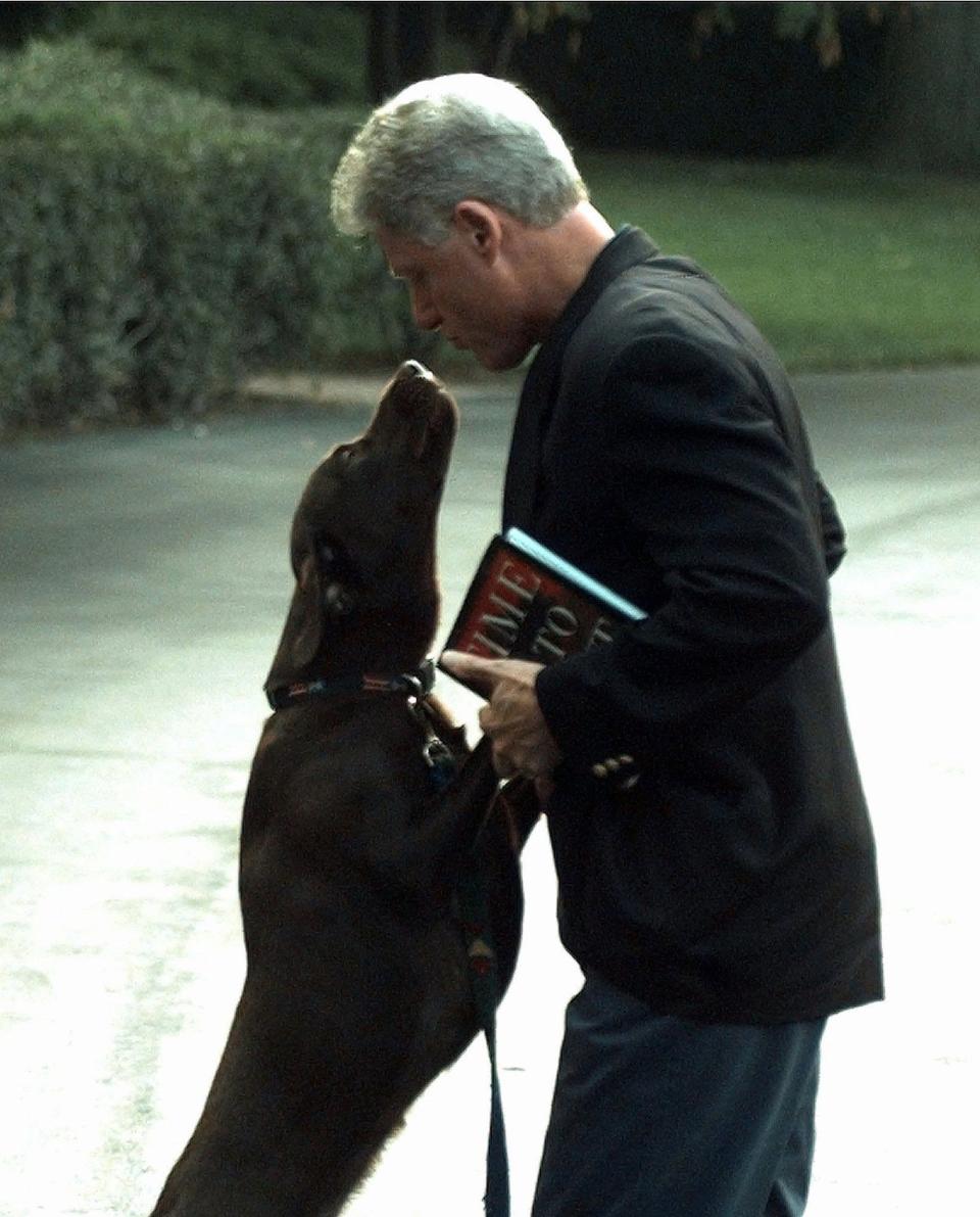 President Bill Clinton is greeted by his dog Buddy in 1998.