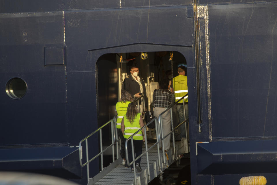 Greek healthcare ministry officials enter the Mein Schiff 6 cruise ship as the ship is docked at Piraeus port, near Athens on Tuesday, Sept. 29, 2020. Greek authorities say 12 crew members on a Maltese-flagged cruise ship carrying more than 1,500 people on a Greek islands tour have tested positive for coronavirus and have been isolated on board. (AP Photo/Petros Giannakouris)