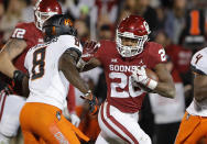 Oklahoma running back Kennedy Brooks (26) runs as Oklahoma State cornerback Rodarius Williams (8) comes in for the tackle in the second half of an NCAA college football game in Norman, Okla., Saturday, Nov. 10, 2018. Oklahoma won 48-47. (AP Photo/Alonzo Adams)