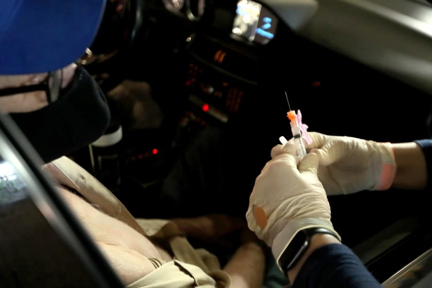 LONG BEACH, CA. - JAN. 21, 2021. Dr. Sarah Mohtadi administers coronavirus vaccine at a drive-in vaccination site at the Long Beach Convention Center on Thursday, Jan. 21, 2021. (Luis Sinco/Los Angeles Times)