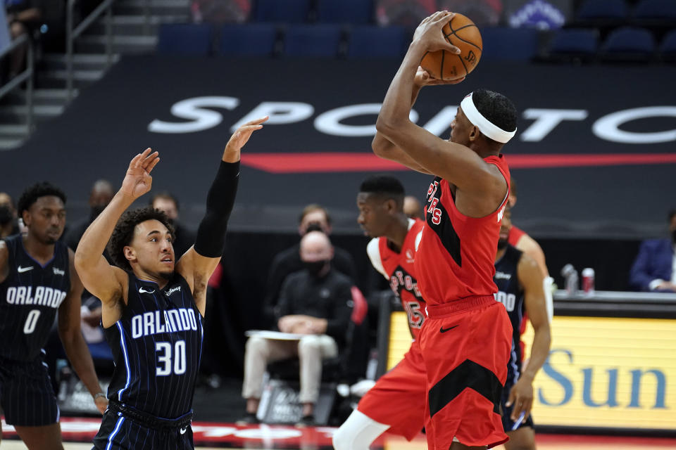 Toronto Raptors guard Paul Watson Jr., (1) puts up a three-point shot over Orlando Magic guard Devin Cannady (30) during the second half of an NBA basketball game Friday, April 16, 2021, in Tampa, Fla. (AP Photo/Chris O'Meara)