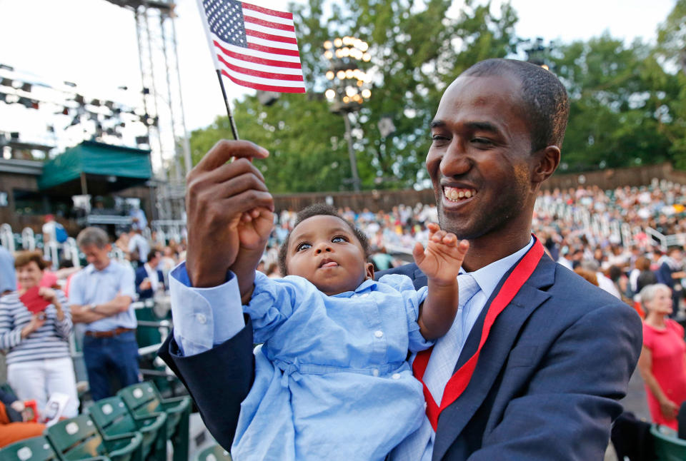 <p>Alpha Saliou Diallo, an refugee from Guinea, holds his daughter Aisha after he became a U.S citizen during a special naturalization ceremony commemorating World Refugee Day at the Delacorte Theater in Central Park, Monday, June 20, 2016, in New York. (Photo: Kathy Willens/AP) </p>