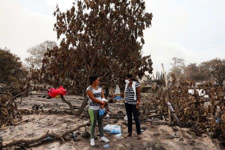 Eufemia Garcia, 48, who lost 50 members of her family during the eruption of the Fuego volcano, talks to Damaris Toma, who is looking for her daughter Emily in San Miguel Los Lotes, Escuintla, June 9, 2018. Picture taken June 9, 2018. REUTERS/Carlos Jasso