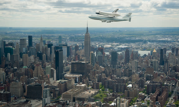 Space shuttle Enterprise, mounted atop a NASA 747 Shuttle Carrier Aircraft (SCA), is seen as it flies near the Empire State Building, Friday, April 27, 2012, in New York.