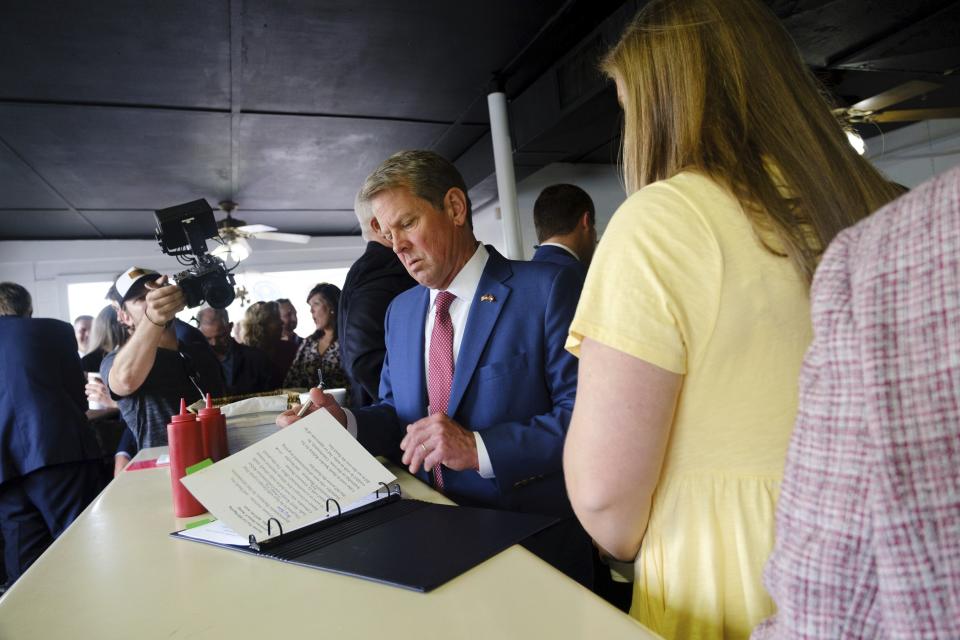 Gov. Brian Kemp reviews notes at the White Diamond Grill in Bonaire, Ga., before he signs a $1 billion tax cut bill on Tuesday, April 26, 2022. Kemp signed the tax cut in former U.S. Sen. David Perdue's hometown of Bonaire at a barbecue restaurant once featured in a Perdue campaign ad. Perdue is running against Kemp for the Republican nomination for governor and early in-person voting starts Monday for the May 24 primary. Democrat Stacey Abrams awaits the winner. /Atlanta Journal-Constitution via AP)