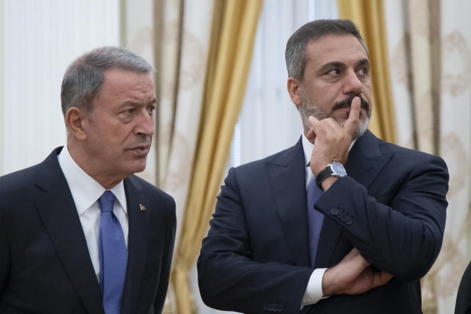 Turkish intelligence chief Hakan Fidan, right, and Turkish Defense Minister Hulusi Akar wait to attend the talks with Russian President Vladimir Putin in the Kremlin in Moscow, Russia, Friday, Aug. 24, 2018. Turkey's Foreign Minister on Friday warned against a possible Syrian government offensive on the last remaining stronghold of opposition against President Bashar Assad, while Russia indicated that it's losing its patience with the rebels. (AP Photo/Alexander Zemlianichenko, Pool)