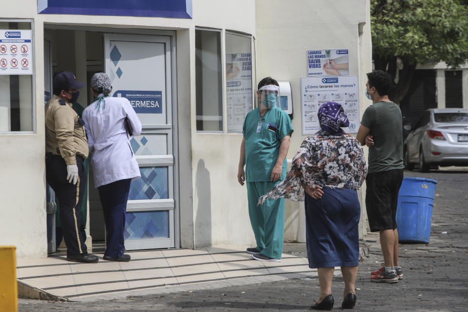 A medical worker wears a mask and a face shield at the entrance of the SERMESA hospital in Managua, Nicaragua, Monday, May 11, 2020. President Daniel Ortega's government has stood out for its refusal to impose measures to halt the new coronavirus for more than two months since the disease was first diagnosed in Nicaragua. Now, doctors and family members of apparent victims say, the government has gone from denying the disease's presence in the country to actively trying to conceal its spread. (AP Photo/Alfredo Zuniga)