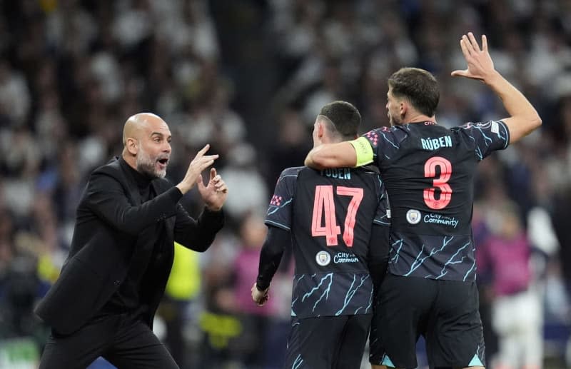 Manchester City's Phil Foden (C) celebrates scoring his side's second goal with manager Pep Guardiola (L) and Ruben Dias during the UEFA Champions League quarter-final first leg soccer match between Real Madrid and Manchester City at the Santiago Bernabeu Stadium. Nick Potts/PA Wire/dpa