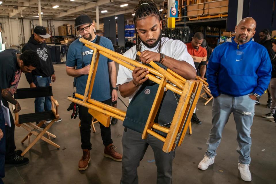 Jessie, 26, learns how to unfold a director's chair during a ManifestWorks workshop