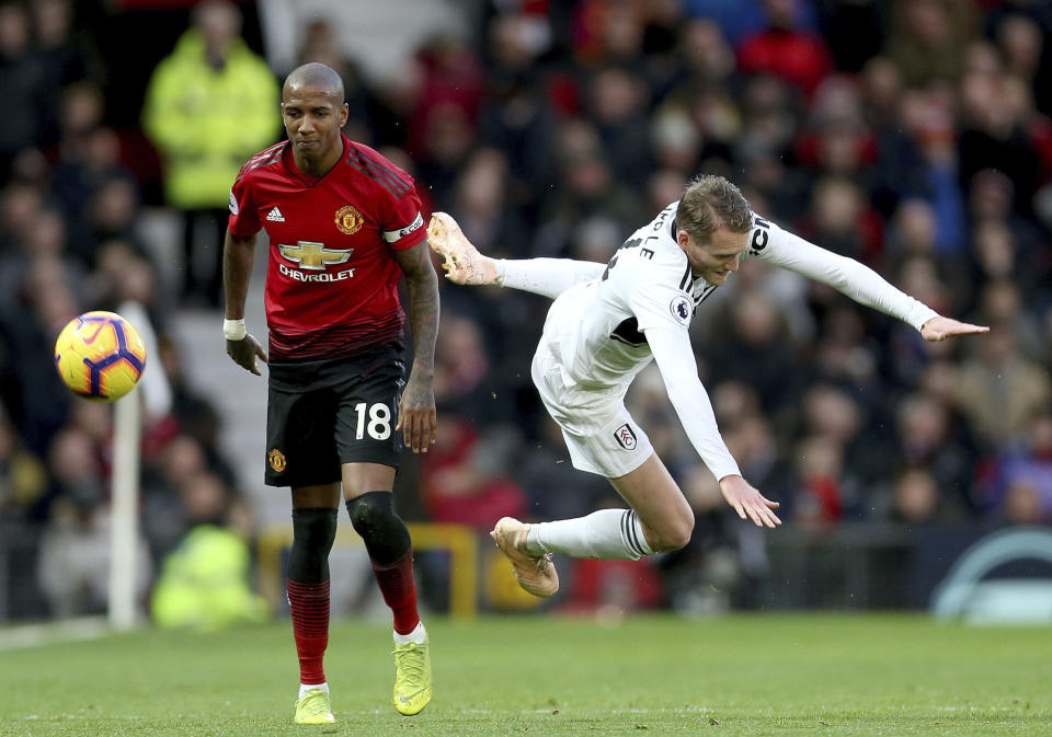 Manchester United's Ashley Young, left and Fulham's Andre Schurrle battle for the ball during the English Premier League soccer match between Manchester United and Fulham, at Old Trafford, Manchester, England, Saturday, Dec. 8, 2018. (Barrington Coombs/PA via AP)