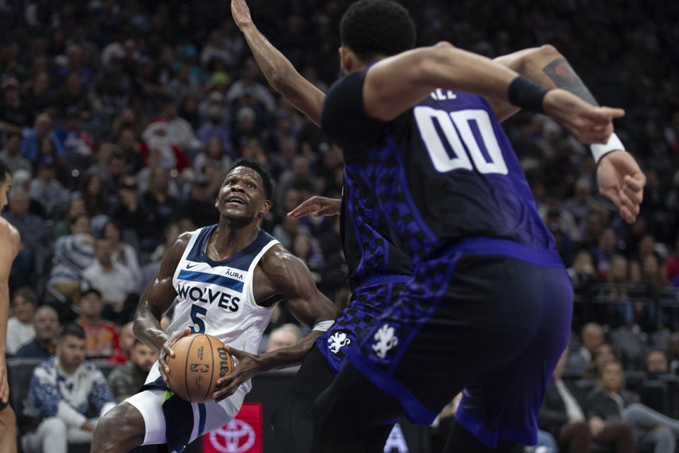 Minnesota Timberwolves guard Anthony Edwards (5) drives into the key as Sacramento Kings center JaVale McGee (00) comes to defend in the first quarter of an NBA basketball game in Sacramento, Calif., Saturday, Dec. 23, 2023. (AP Photo/José Luis Villegas)