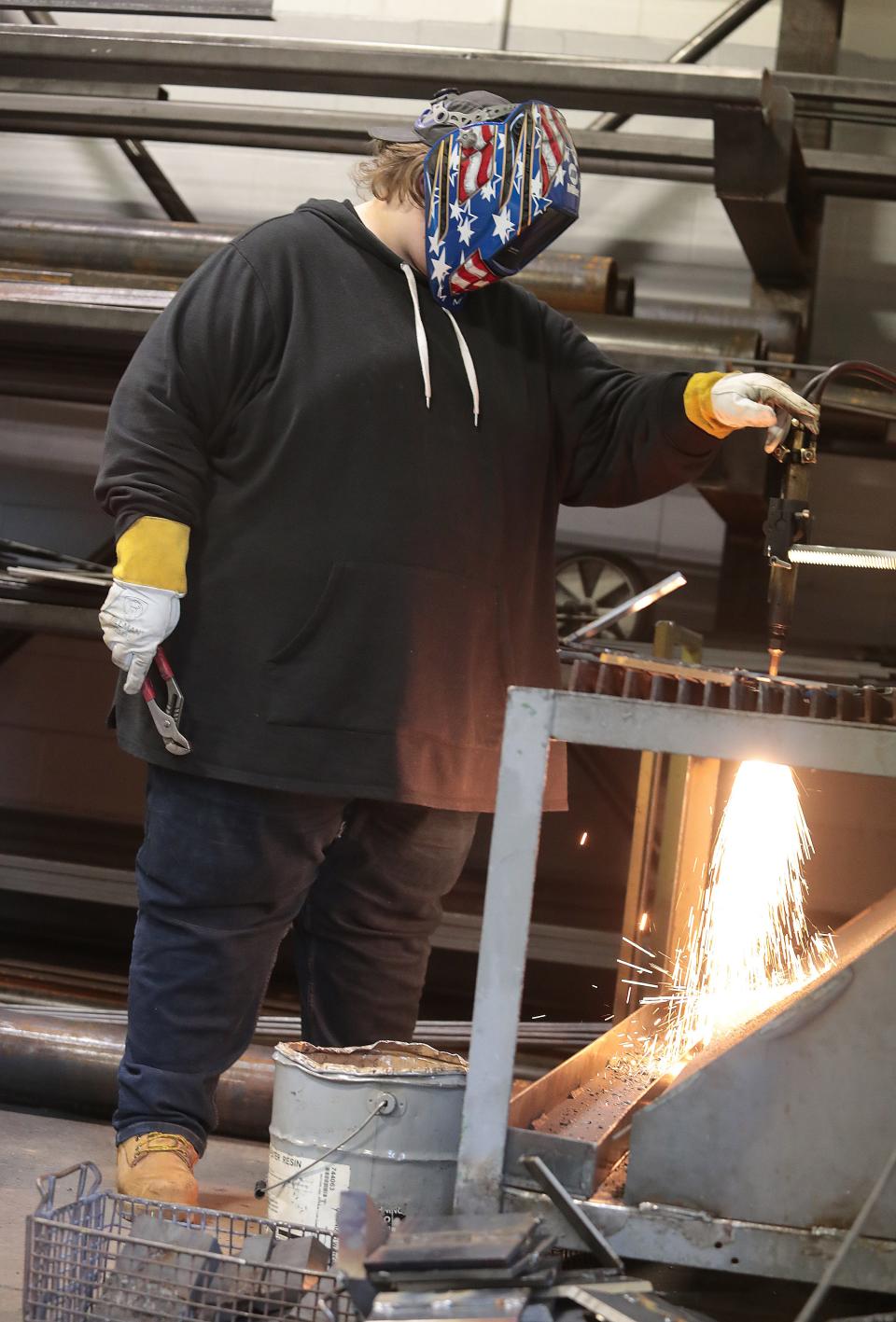 Louisville High senior Riley Gfeller uses a track torch to cut metal practice plates in class at R.G. Drage. The school's enrollment is at an all-time high.