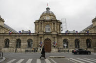 A man walks past the Senate, Sunday, Sept.27, 2020 in Paris. Nearly half of France's Senate seats are up for grabs in elections Sunday that are likely to leave the chamber dominated by conservatives and serve a new electoral blow to President Emmanuel Macron's centrist party. The elections are indirect, with senators chosen primarily by some 75,000 local elected officials like city councilors. They are voting for 172 of the 348 seats in the Senate, whose senators serve six-year terms. (AP Photo/Lewis Joly)